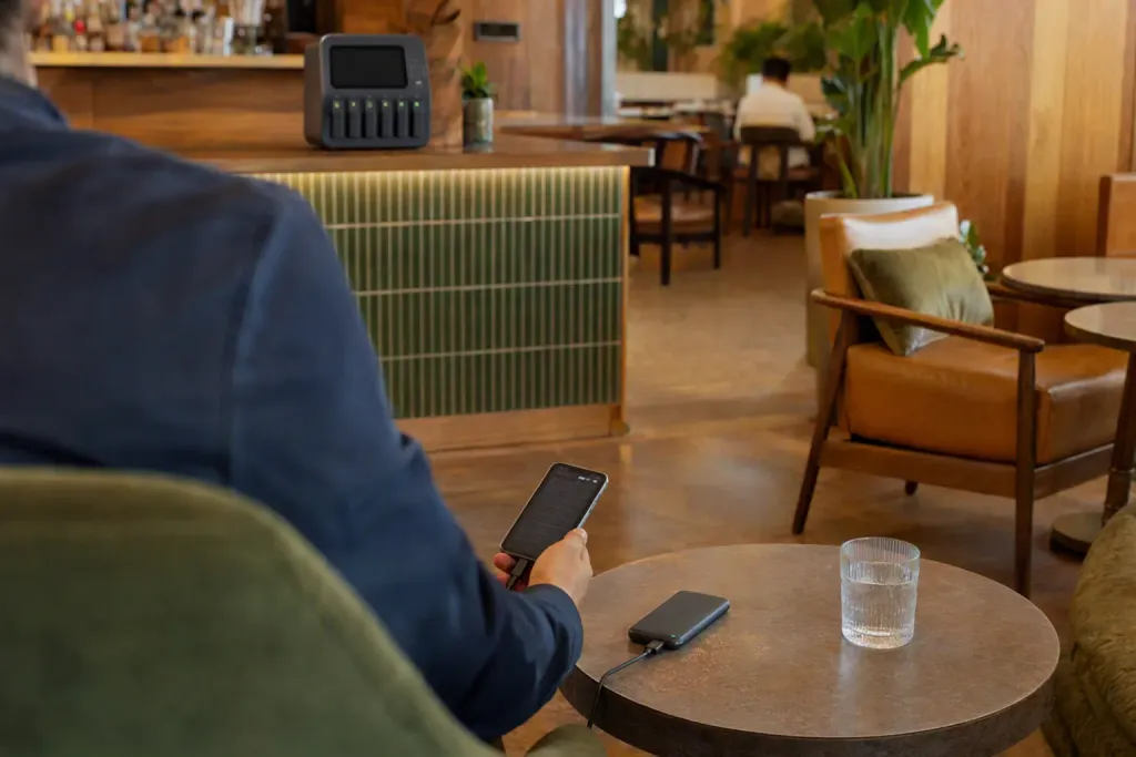 A hotel lobby bar, a guest's phone charging on a low table